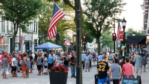 Crowd of people walking downtown at an evening community street festival